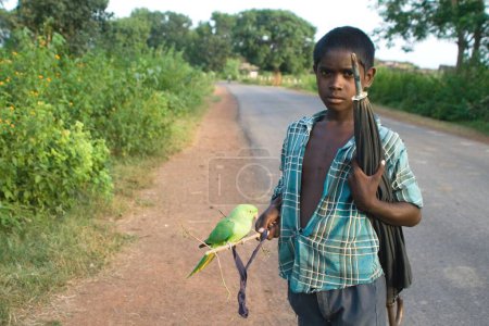 Photo for Boy holding parrot and umbrella in hand, India - Royalty Free Image