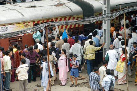 Foto de Los viajeros tratan de llegar en tren local lleno de gente durante la hora pico en la estación de tren de Ghatkopar en Bombay Mumbai, Maharashtra, India - Imagen libre de derechos
