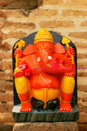 Orange and yellow colored idol of lord Ganesh ganpati elephant headed god ; Wai ; Maharashtra ; India