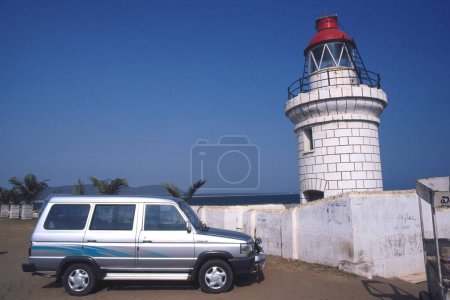 Téléchargez les photos : Voiture quallis est garée près de vieux phare à la plage bheemunipatnam, andhra pradesh, Inde - en image libre de droit