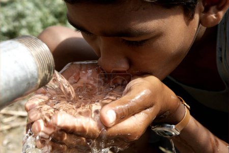 Girl drinking water from water pump ; Hazaribagh ; Jharkhand ; India
