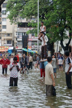 Téléchargez les photos : Inondation due à de fortes pluies, Montrant la foule appréciant dans l'eau de pluie, mousson, pluie record du monde sur la route de Jambhali Naka à la gare de Thane, jouxtant Masoonda Talao, chemin Shivaji, Thane, Maharashtra, Inde - en image libre de droit