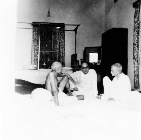Foto de Mahatma Gandhi, hablando con Mahadev Desai y Madan Mohan Malaviya en Birla House, Nueva Delhi, 1939, India - Imagen libre de derechos