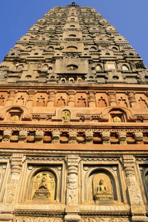 mahabodhi temple ; budha carved in different aspect on wall and soaring tower ; bodhgaya ; bihar ;  india
