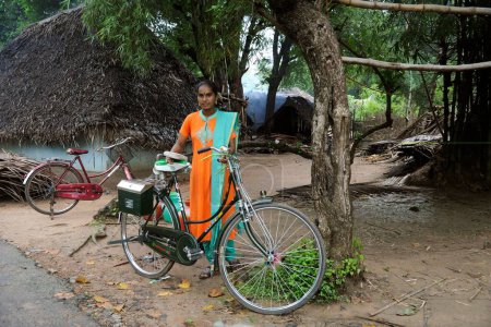 Téléchargez les photos : Bénévole avec cycle par ngo kshtriya gramin services financiers par la fondation IFMR, Thanjavur, Tamil Nadu, Inde - en image libre de droit