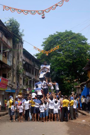 Photo for Human pyramid trying to break dahi handi on janmashtami festival at dadar, Bombay, Mumbai, Maharashtra, India - Royalty Free Image
