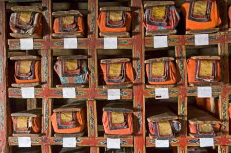 Sagradas escrituras budistas en Ladakh; Jammu y la lengua cachemira escrito a mano en papel horizontal largo envuelto en tela colorida con placa de madera en la parte superior e inferior; apilado cuidadosamente en la biblioteca del monasterio de Tikse; Ladakh; Jammu y Cachemira; En