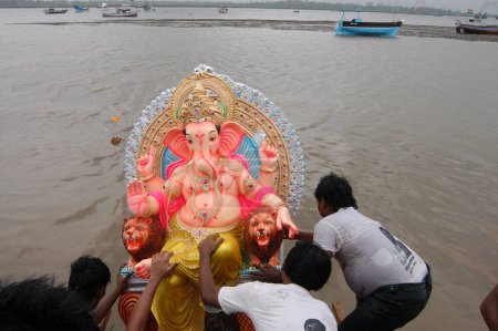 Foto de Los devotos sumergen enorme ídolo de Ganesh en el mar en Versova, Bombay Mumbai, Maharashtra, India - Imagen libre de derechos