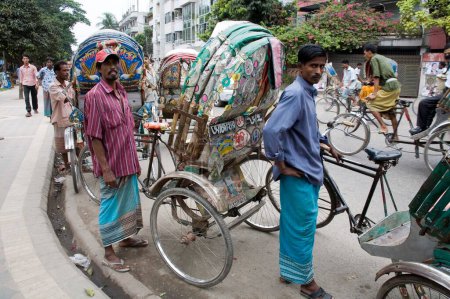 Foto de Rickshaw pullers standing on road, street scene, Dhaka, Bangladesh - Imagen libre de derechos