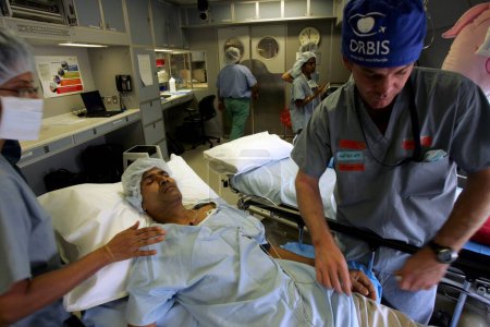 Téléchargez les photos : Un groupe de médecins traitant un patient à bord de l'avion ORBIS Flying Eye Hospitals récemment atterri à l'aéroport international Chhatrapati Shivaji, Bombay Mumbai, Maharashtra - en image libre de droit
