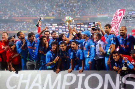 Téléchargez les photos : Les joueurs de cricket indiens célèbrent avec le trophée après avoir battu le Sri Lanka lors du match final de la Coupe du monde de cricket 2011 de l'ICC au stade Wankhede à Mumbai en Inde le 2 avril 2011.. - en image libre de droit