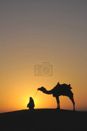 Foto de Glorioso hombre del amanecer con camello en dunas de arena; Jaisalmer; Rajasthan; India - Imagen libre de derechos