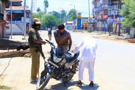 Photo for Policeman checking bike during death anniversary of Hizbul Mujahideen, Kashmir, India, Asia - Royalty Free Image