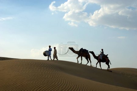 Photo for Men with camels walking on sand dune of khuhri, Jaisalmer, Rajasthan, India - Royalty Free Image