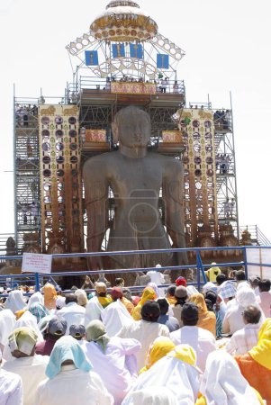 Photo for Jain devotees participating and Praying of 58.8 feet monolithic Statue of jain saint Gomateshwara Lord Bahubali in Mahamastakabhisheka on the Vindhyagiri hill, Shravanbelagola, Karnataka, India - Royalty Free Image