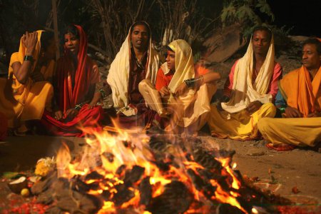Photo for Eunuchs sitting around burning pyre during wedding of eunuchs on occasion of Bewa Purnima at Ghatkopar ; Bombay now Mumbai ; Maharashtra ; India - Royalty Free Image
