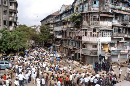 Téléchargez les photos : Des policiers inspectant le site de l'explosion de bombe ont également rassemblé un grand nombre de personnes pour regarder le site de Zaveri Bazaar dans la zone occupée de Kalbadevi ; Bombay Mumbai, Maharashtra, Inde Le 26 août 2003 - en image libre de droit