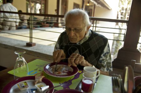 Téléchargez les photos : Vieil homme prenant le petit déjeuner, station mahindra, coorg, Karnataka, Inde, asie - en image libre de droit