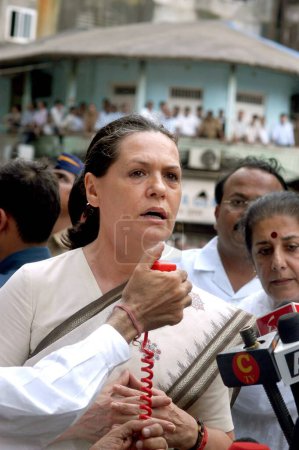 Photo for Congress President Sonia Gandhi spoke to media personnel mike at the site of bomb blast at Zaveri Bazaar in busy Kalbadevi area, Bombay Mumbai, Maharashtra, India August 26th 2003 - Royalty Free Image