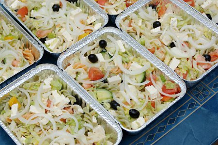 Photo for Food , Greek Salad with Olives and Feta cheese Packed food of one portion in aluminum foil container many containers with salad leaves cucumber , onion , tomatoes , pasta - Royalty Free Image