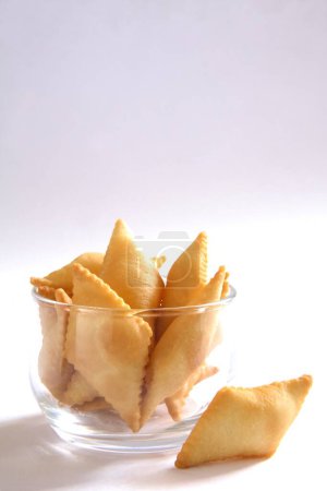 Süßer Snack; Shakkarpara aus Maida-Weizenmehl und Zucker in einer Schüssel auf weißem Hintergrund