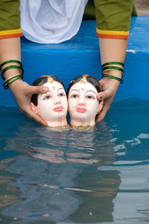 Téléchargez les photos : Femme faisant immersion de la déesse gauri dans un réservoir artificiel à Pune, Maharashtra, Inde - en image libre de droit