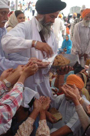 Téléchargez les photos : Prasad distributeur prêtre dans le temple d'or, Amritsar, Punjab, Inde - en image libre de droit