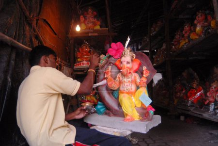 Photo for A sculptor gives final touch to a lord Ganesh idol at a workshop in Lalbaug for Ganesh ganpati festival ; Bombay now Mumbai ; Maharashtra ; India - Royalty Free Image