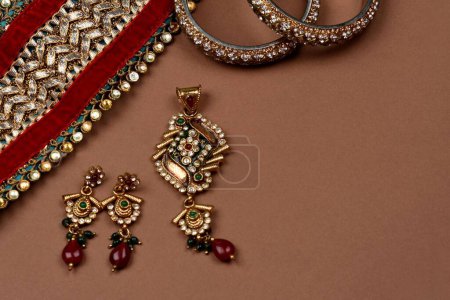 Téléchargez les photos : Bijoux anciens sur fond brun, écharpe dorée, bracelet en or, fond de bijoux, collier en or, boucles d'oreilles en or, bague doigt. Style, mode et design de bijoux. bijoux traditionnels indiens - en image libre de droit