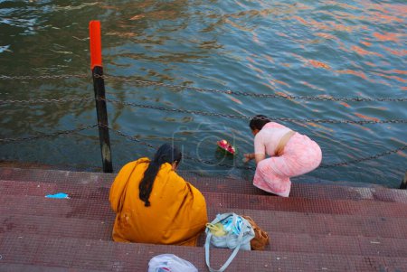 Téléchargez les photos : Femme offrant un daan profond dans le Ganga, Hardwar, Uttar Pradesh, Inde - en image libre de droit