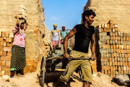 Photo for Man carrying bricks on hand cart in Brick factory, India, Asia - Royalty Free Image