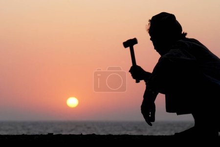 Photo for A construction labourer works during sunset at Marine Drive ; Bombay now Mumbai ; Maharashtra ; India - Royalty Free Image