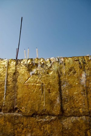 Vela derretida cera y hojas de oro pegadas en las paredes del santuario de monasterios en ruinas cerca de Dhamekh stupa; Sarnath; Varanasi; Uttar Pradesh; India