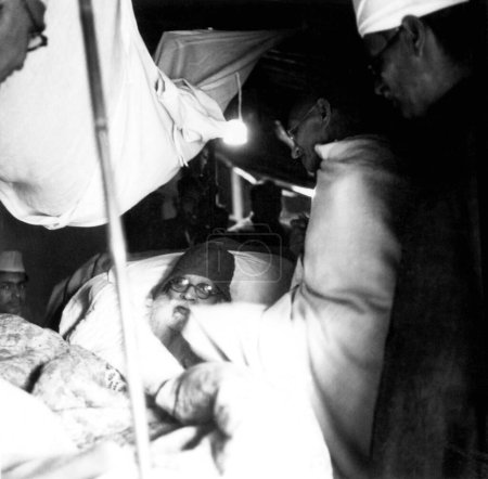 Téléchargez les photos : Mahatma Gandhi visitant le constructeur du temple Bharat Mata, Shivprasad Gupta, malade, à Varanasi, 1941, Inde - en image libre de droit