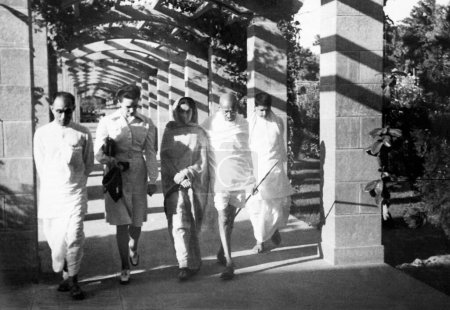 Foto de Mahatma Gandhi, caminando con Pyarelal Nayar, su hijo Devdas y otros, 1945, India NO MR - Imagen libre de derechos