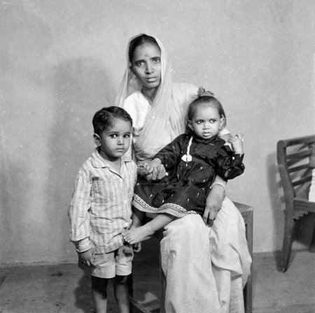 Photo for Old vintage 1900s black and white picture of Indian family studio portrait woman sitting wearing sari son daughter India 1940s - Royalty Free Image