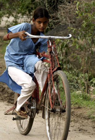 Foto de Girl riding bicycle, Dilwara town, Rajasthan, India - Imagen libre de derechos