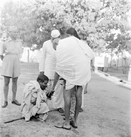Foto de Mahatma Gandhi, saludando a un ciego durante su visita a las zonas afectadas por los disturbios de Bihar, 1947, India - Imagen libre de derechos