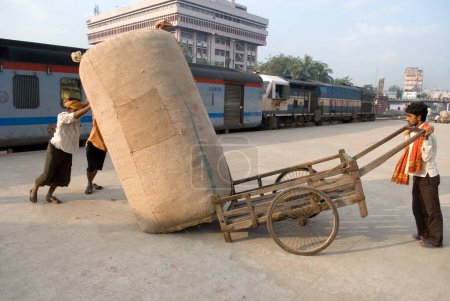Foto de Trabajadores arrastrando equipaje en la plataforma ferroviaria, Guwhati, Assam, India - Imagen libre de derechos