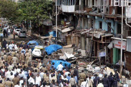 Photo for Policemen inspecting site of bomb blast also large number of people gathered to look at the site at Zaveri Bazaar in busy Kalbadevi area, Bombay Mumbai, Maharashtra, India August 26th 2003 - Royalty Free Image