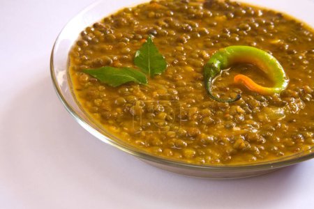 Téléchargez les photos : Indian masoor dal  red gram lentil soup garnish with curry leaves and chilli in glass bowl on white background - en image libre de droit