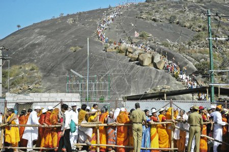 Téléchargez les photos : Une foule immense de pèlerins s'alignent pour monter à la sainte statue du Seigneur bahubali dans le cadre du festival jaïn de Mahamastakabhishek, tenu une fois tous les 12 ans, Shravanbelgola, Karnataka, Inde - en image libre de droit
