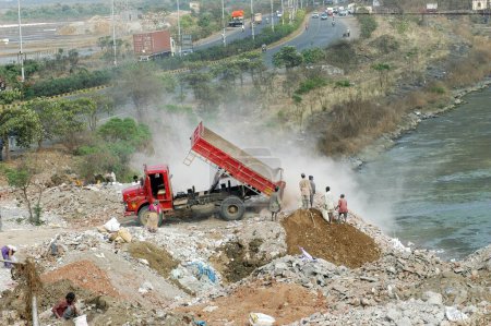 Foto de Camiones arrojan escombros en la tierra salina en la Eastern Express Highway en Bombay ahora Mumbai; Maharashtra; India - Imagen libre de derechos