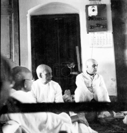 Foto de Sardar Vallabhbhai Patel y Jawaharlal Nehru escuchando un informe sobre disturbios en Calcuta en Khadi Pratishthan, Sodepur, 24 Parganas, Calcuta, 1946, India - Imagen libre de derechos