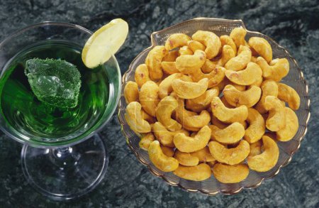 Foto de Frutos secos, anacardos con sabor a Kesar y vaso de jugo - Imagen libre de derechos