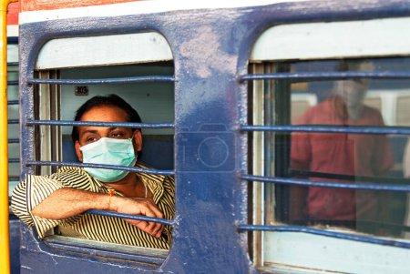 Téléchargez les photos : Visage couvert de banlieue avec masque de protection contre la grippe porcine voyageant en train ; Bombay Mumbai ; Maharashtra ; Inde 12-août-2009 NOMR - en image libre de droit
