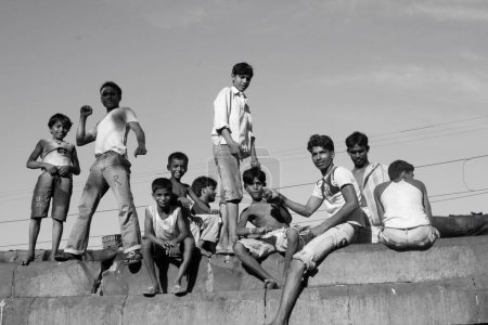 Foto de Niños de tugurios disfrutando y parados en la pared, Bombay Mumbai, Maharashtra, India - Imagen libre de derechos