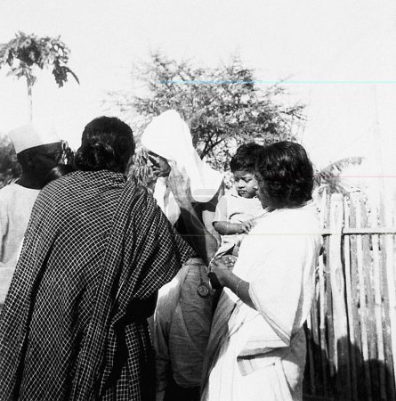 Foto de Mahatma Gandhi con una ashramita y sus parientes en Sevagram Ashram, 1944 - Imagen libre de derechos