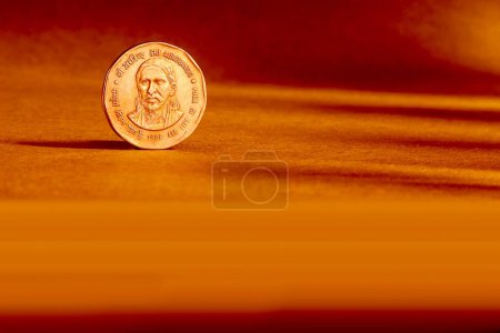 Foto de Una moneda india dos rupias moneda trasera en relieve Sri Aurbindo toda la vida es yoga 1998 sobre fondo naranja - Imagen libre de derechos