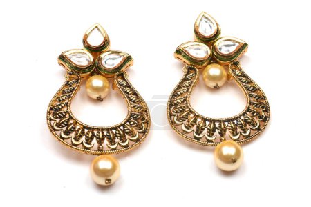 Foto de Hermoso par de pendientes de oro Diamantes piedras preciosas sobre fondo blanco. Joyas femeninas de lujo, joyas tradicionales indias, pendientes kundan, pendientes de oro nupcial joyas de boda - Imagen libre de derechos